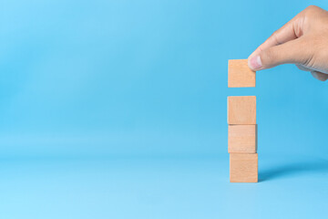 Four blank wooden dices stacked vertically. Minimalist concept for planning, structure, balance, or...