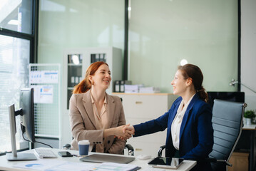 Businesswoman leading team meeting and using tablet and laptop computer with financial