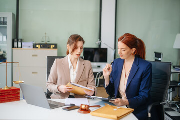 Professional female lawyers consulting on legal cases in a modern office. Perfect for law, business, justice