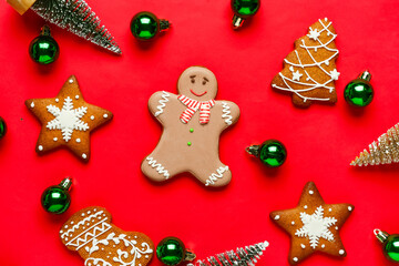 Gingerbread cookies with Christmas decor on red background