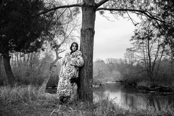 Portrait of a young beautiful dark-haired girl in a leopard fur coat. Black and white photo.