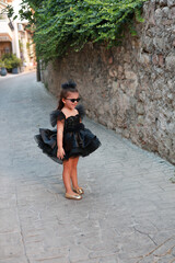 a little girl wearing a black dress like a Chanel model