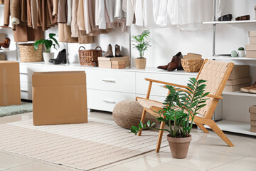 Interior of modern dressing room with wardrobe boxes, stylish clothes and accessories