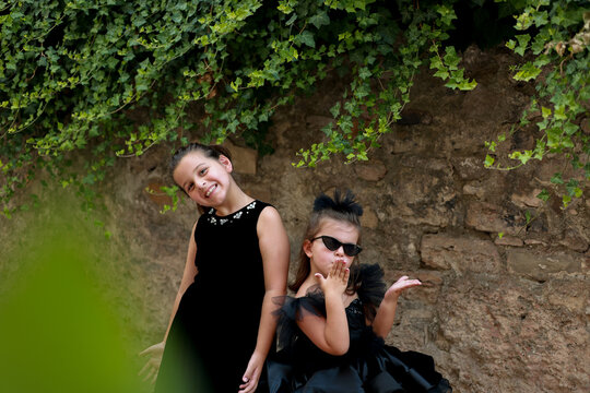 a little girl wearing a black dress like a Chanel model