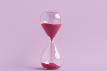 Hourglass on lilac background. Time management concept