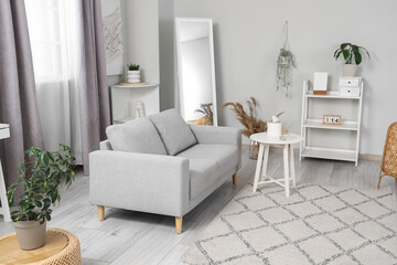 Light modern living room with cozy couch, coffee table and carpet