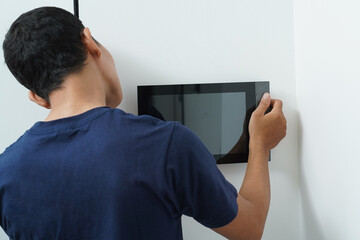 Worker with tablet computer checking alarm system