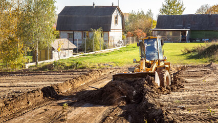 Yellow bulldozer at a construction site. Big wheel excavator leveling and clearing the land plot...