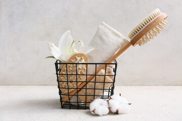 Beautiful composition with bath supplies and lily flower in metal basket and cotton flowers on...