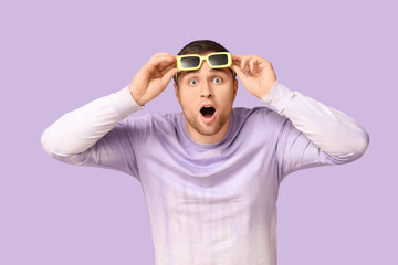 Shocked young man in glasses on lilac background