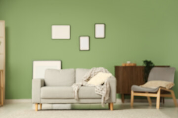 Stylish interior of modern living room with blank picture frames and comfortable sofa