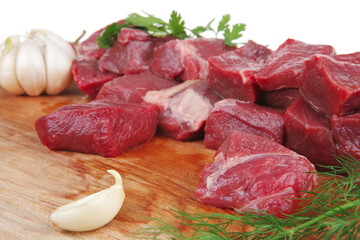 Fresh raw beef steak with rosemary, vegetables, and other ingredients on a cutting board, ready for...