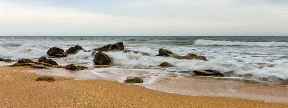 A beach on the Atlantic coast of Florida with waves crashing on the coquina rock