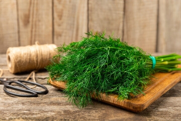 Dill on wooden background. Fresh organic greens. Dill plantation. Cut dill leaves. Bunch of spring...
