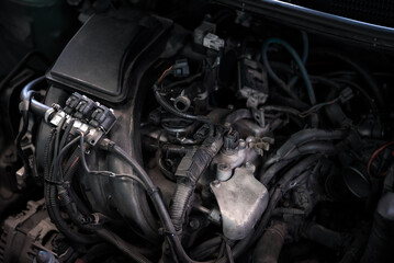 Car mechanic drain the old lubricant engine oil at car garage for changing the oil in a car engine