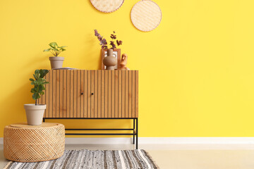 Interior of stylish room with commode and artificial plants