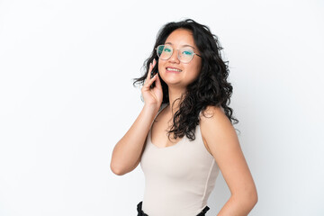 Fototapeta premium Young asian woman isolated on white background keeping a conversation with the mobile phone with someone