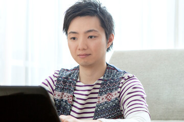 リビングでパソコンを操作する男性
