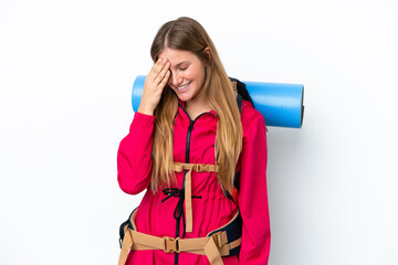 Young mountaineer girl with a big backpack over isolated white background laughing