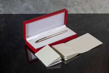 Fountain pen with box on dark gray background. Stationery branded items
