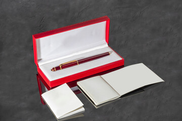 Fountain pen with box on dark gray background. Stationery branded items
