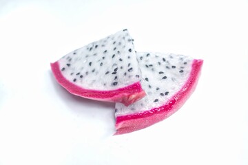 Fresh dragon fruit, sliced ​​into small pieces arranged on a white background.