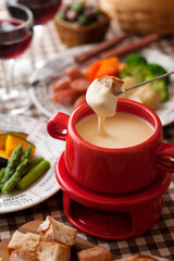 【チーズフォンデュ】温めた鍋でチーズを白ワインでゆっくり溶かしフランスパン・ソーセージ・野菜にからめて愉しみます。