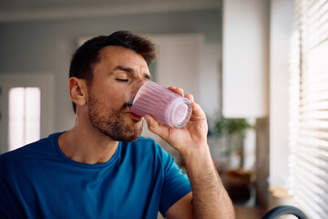 Man with eyes closed enjoying in healthy smoothie in morning.