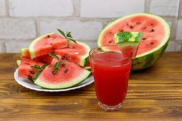Glass of fresh watermelon juice on a wooden table