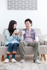 ソファでコーヒーを飲む夫婦