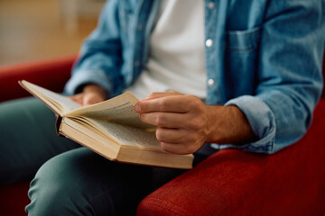 Close up of man reading book at home.