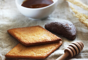 The cookies are lying on a towel on the table, with dry grass and honey nearby.