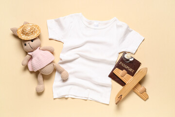 Composition with children's clothes, toys and passport on beige background, closeup