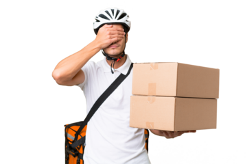 Delivery man wearing a helmet bike over isolated background covering eyes by hands. Do not want to see something