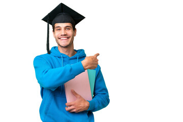 Young university graduate man over isolated background pointing back
