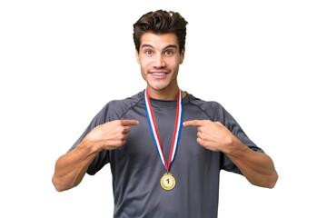 Young caucasian man with medals over isolated background with surprise facial expression