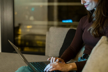 Young woman alone at home working late at night on her laptop. Freelancing, studying, chatting...