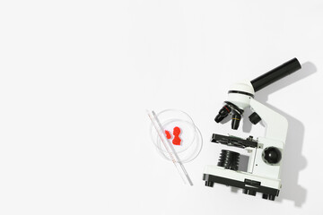 Modern microscope with blood samples and petri dish on white background