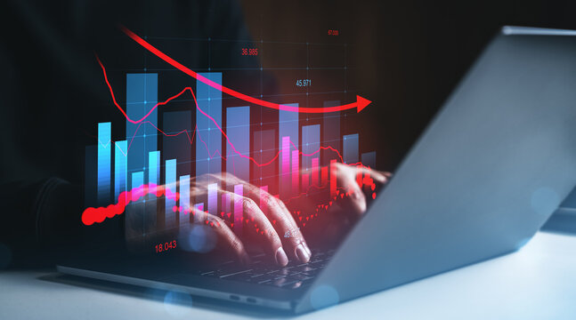 Business analytics and financial data analysis concept with digital bar charts and red arrow over hands typing on laptop in dark environment. - Powered by Adobe