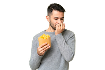 Young caucasian man holding fried chips over isolated chroma key background having doubts