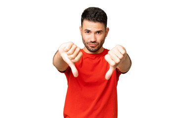 Young handsome caucasian man over isolated chroma key background showing thumb down with two hands