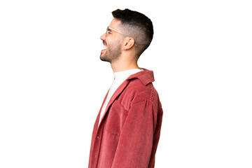Young handsome caucasian man over isolated chroma key background laughing in lateral position