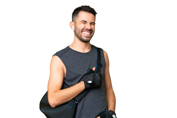 Young sport caucasian man with sport bag over over isolated chroma key background laughing in...