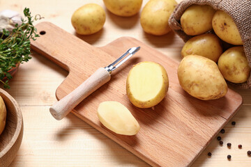 Cutting board with raw baby potatoes, thyme and peppercorns on wooden background, closeup