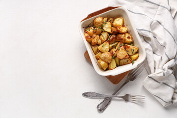 Baking dish of baked baby potatoes with thyme on white background