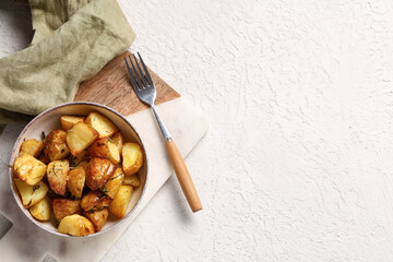 Bowl with baked baby potatoes on white background