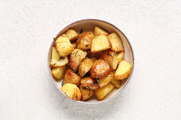 Bowl with baked baby potatoes on white background