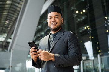 Muslim asian businessman traveler holding boarding pass ticket, passport and smartphone at the...