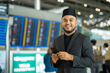 Muslim asian businessman traveler holding boarding pass ticket, passport and smartphone at the...