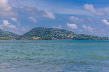 Fototapeta premium View of Patong Beach in the island of Phuket Thailand, turquoise blue waters of the Andaman and lush green mountains